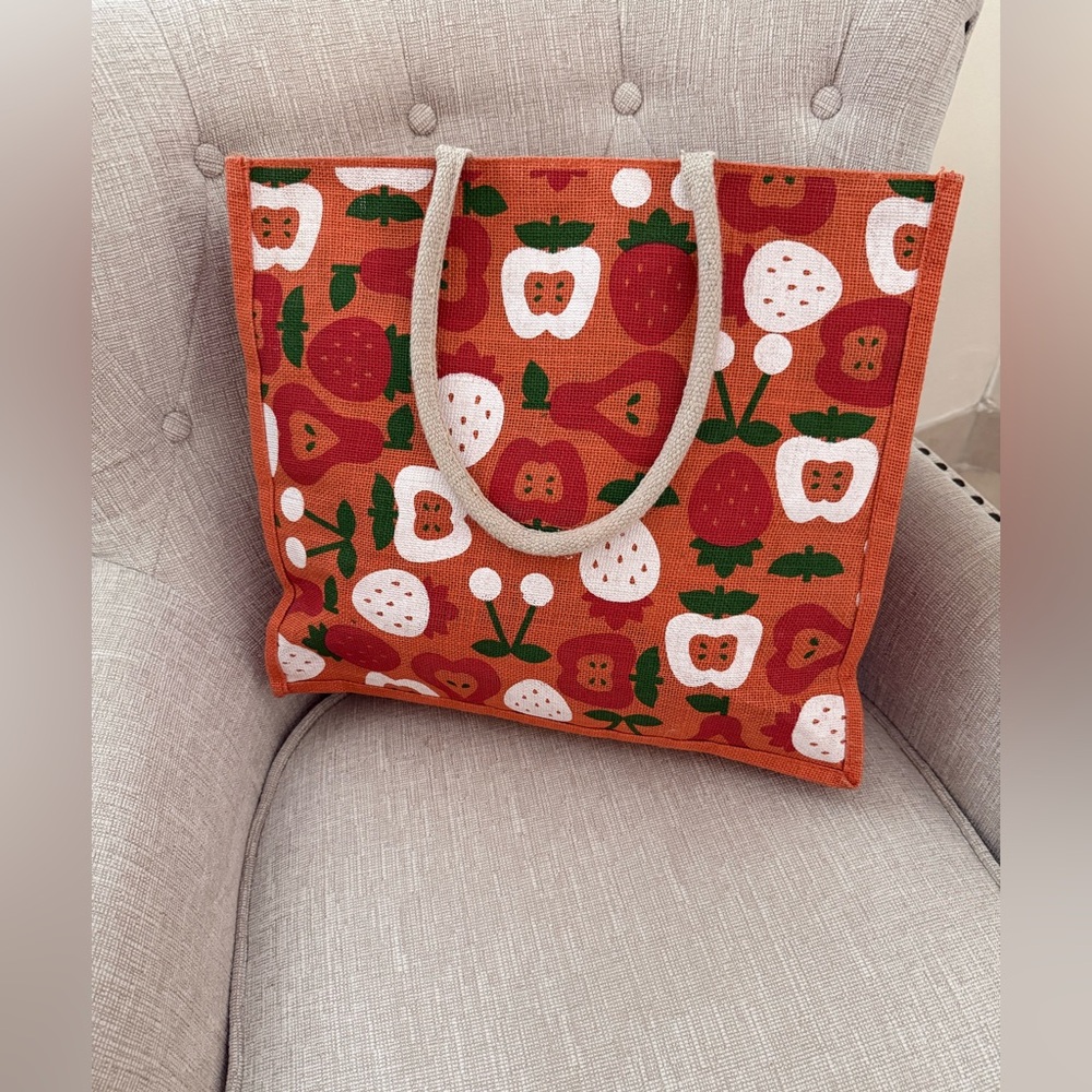 A decorative r’ Straw Tote bag featuring a vibrant fruit pattern.